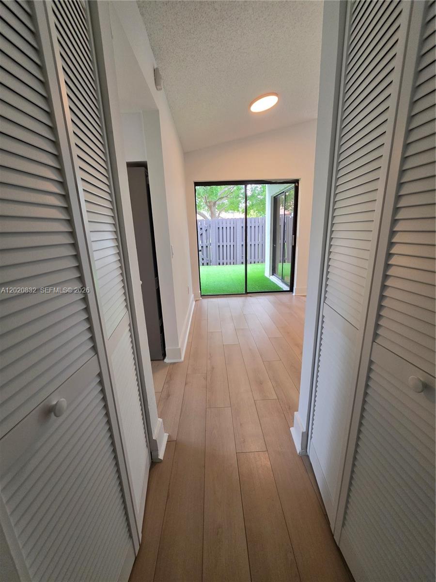 15240 Southwest 45th Terrace, Unit 54F Miami, FL 33185 - Photo 18 of 48 a view of an empty room with wooden floor and a window