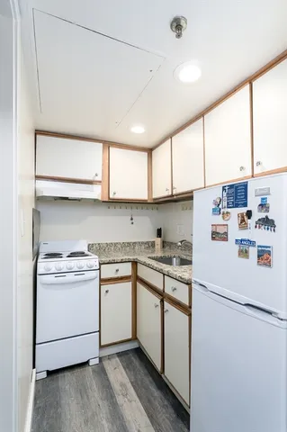 a utility room with stainless steel appliances granite countertop cabinets and a window