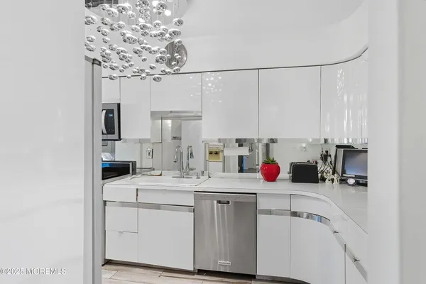 a kitchen with a sink dishwasher and white cabinets
