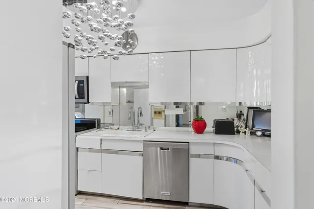 a kitchen with a sink dishwasher and white cabinets