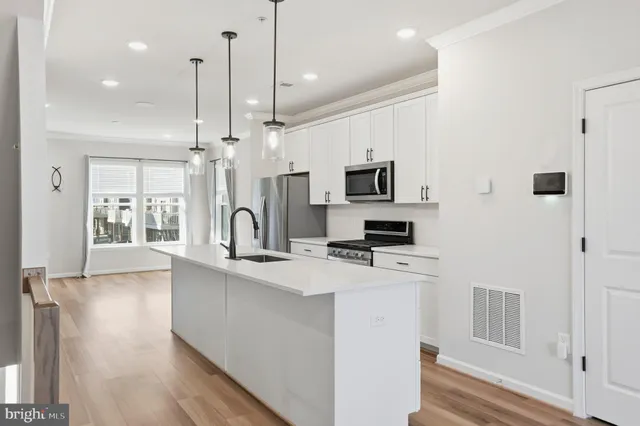 a kitchen with kitchen island a white counter top space a sink and appliances