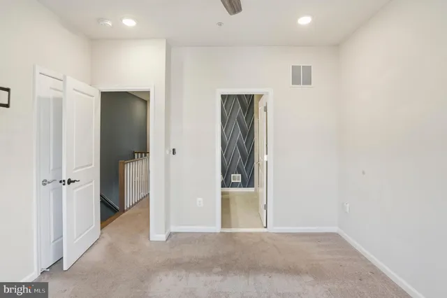 an empty room with closet and mirror