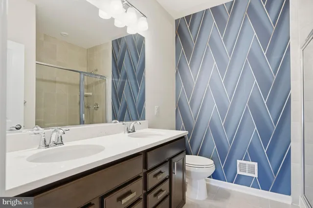 a bathroom with a double vanity sink toilet and a mirror