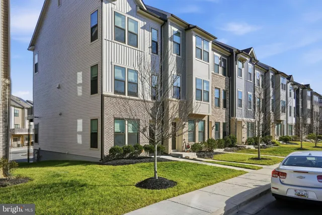 a front view of a building with a lot of windows and plants