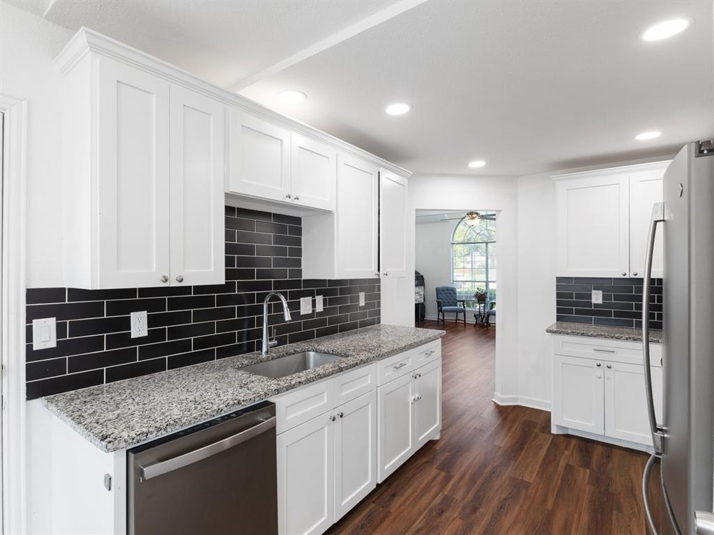 a kitchen with stainless steel appliances kitchen island granite countertop a stove and a sink