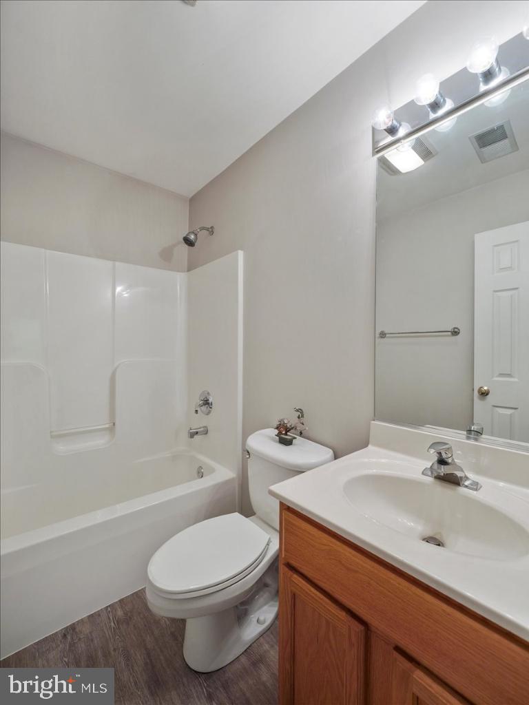 169 Arrowhead Loop Hedgesville, WV 25427 - Photo 12 of 24 a bathroom with a toilet a sink a mirror a bathtub and vanity