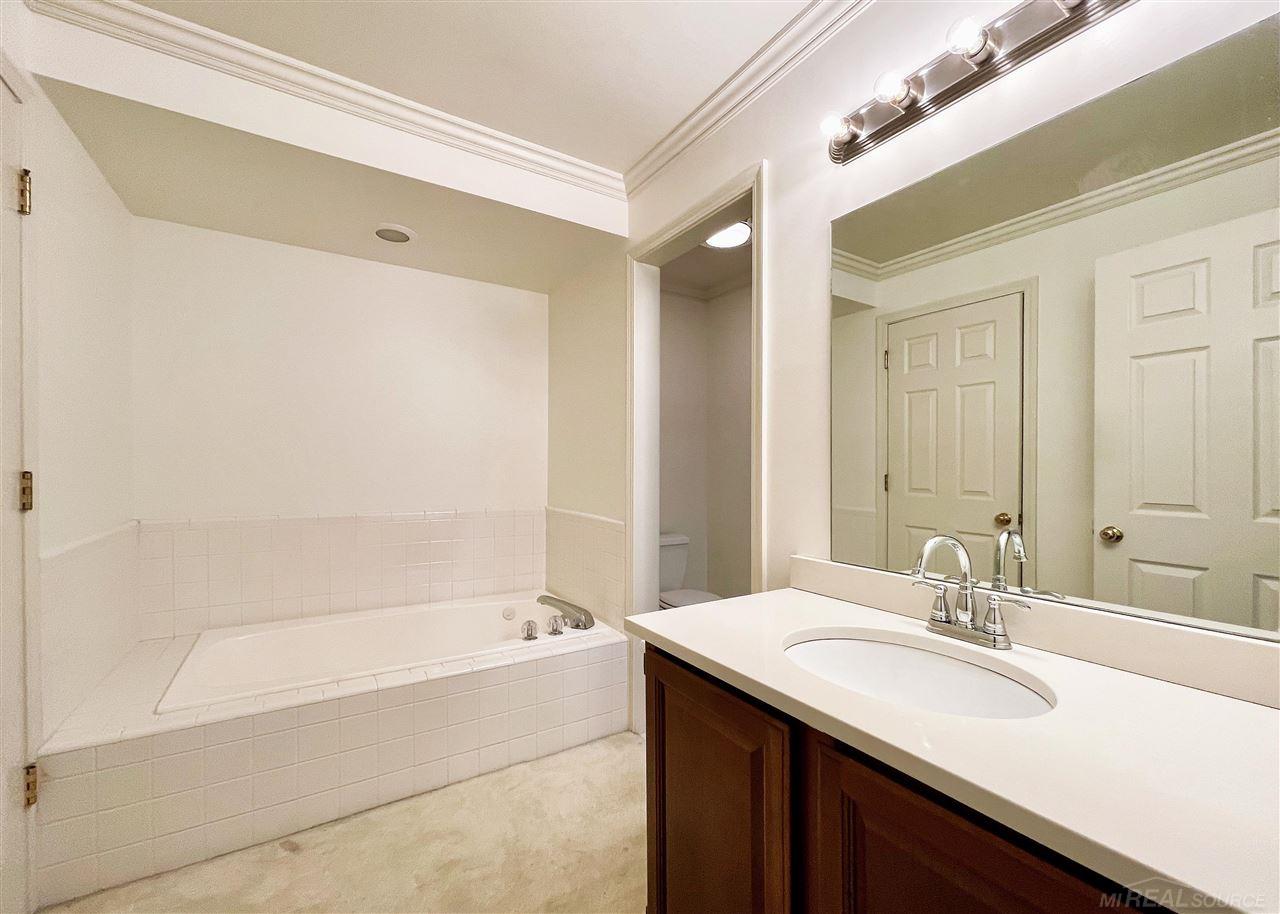 744 Trombley Road Grosse Pointe, MI 48230 - Photo 13 of 32 Freshly painted master bathroom with new quartz vanity top, shower and jetted tub, walk-in closet and access to additional storage space.
