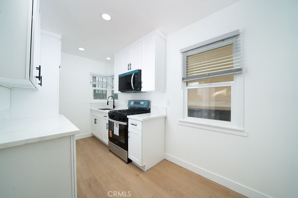 1046 Cedar Avenue Long Beach, CA 90813 - Photo 4 of 8 a kitchen with a sink cabinets stainless steel appliances and a window