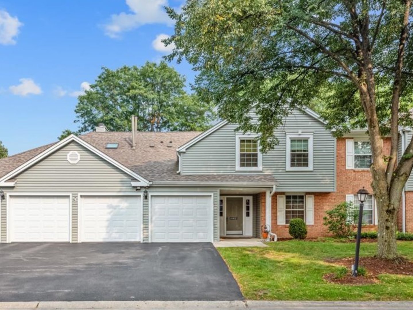 a front view of a house with a yard and trees