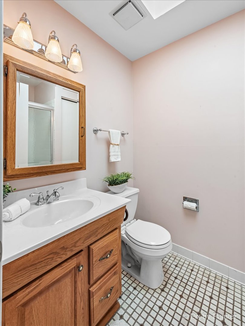 -n021 Windermere Road, Unit 405 Winfield, IL 60190 - Photo 22 of 50 a bathroom with a granite countertop toilet a sink a mirror and a window