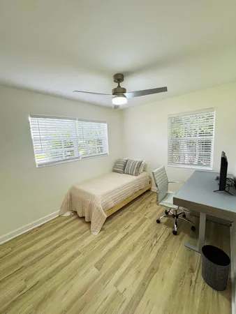 a spacious bedroom with a bed a desk and chair