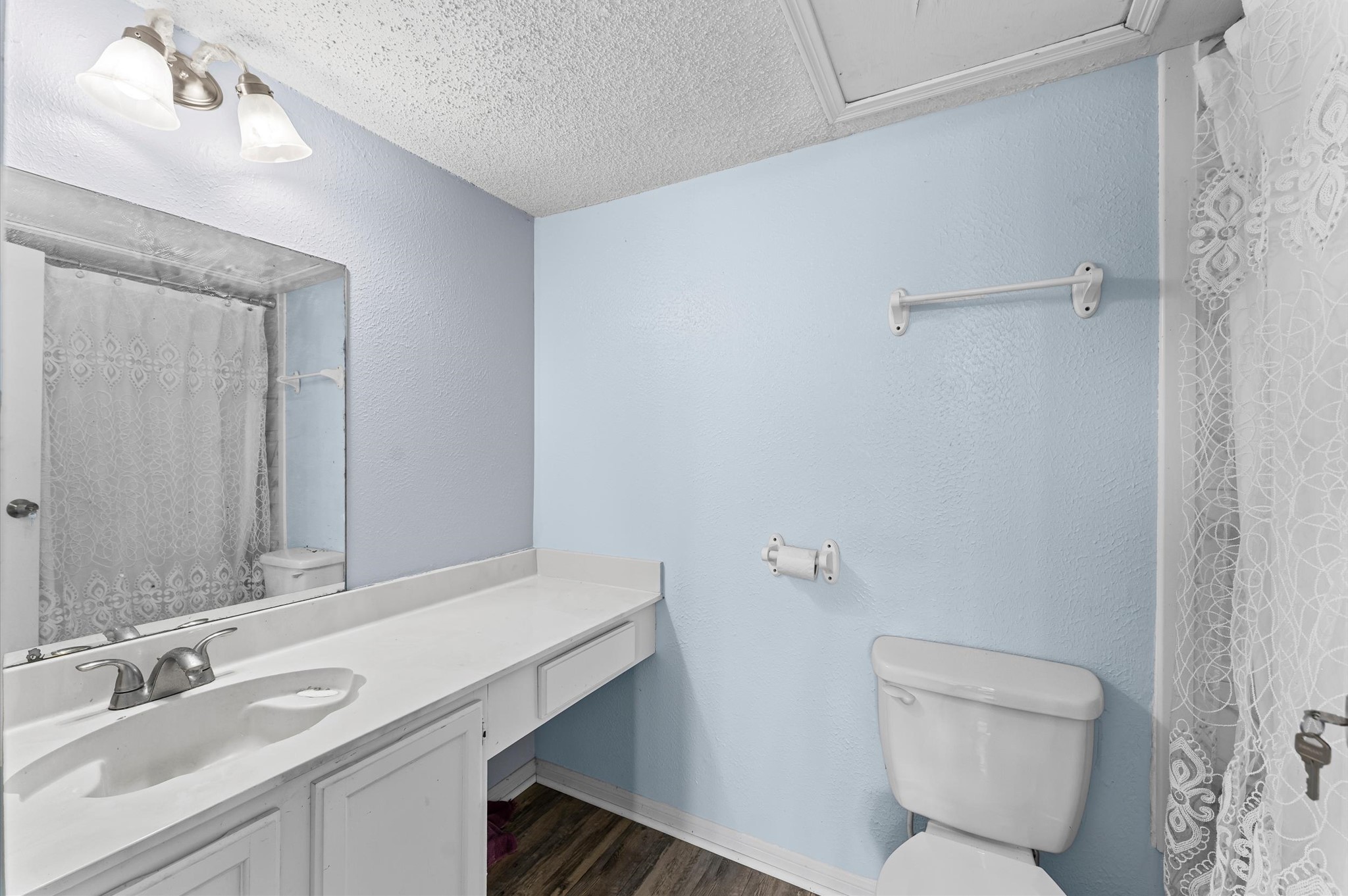 7402 Alabonson Road, Unit 303 Houston, TX 77088 - Photo 16 of 20 a bathroom with a toilet sink and mirror