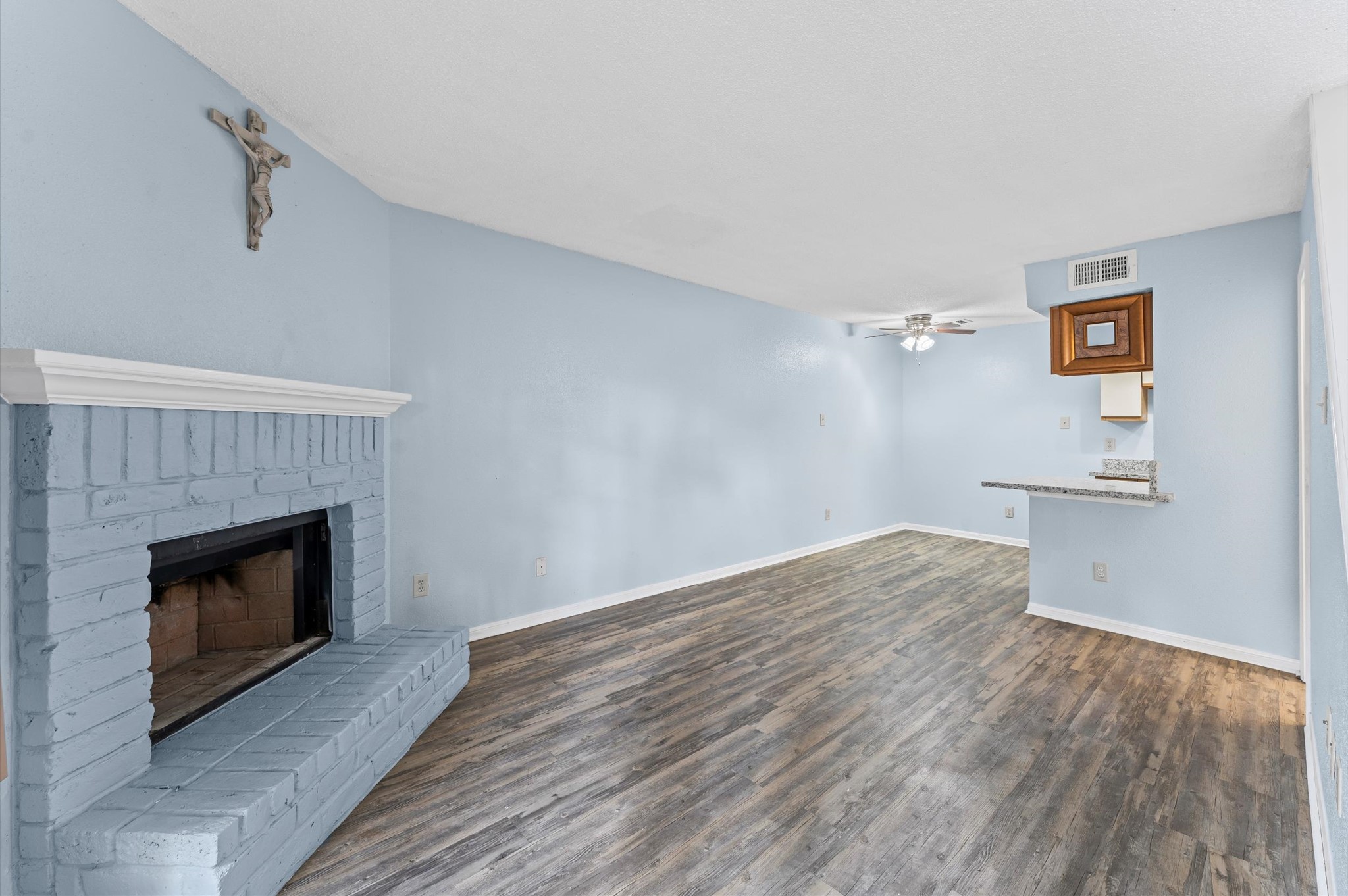 7402 Alabonson Road, Unit 303 Houston, TX 77088 - Photo 5 of 20 a view of empty room with wooden floor and fireplace