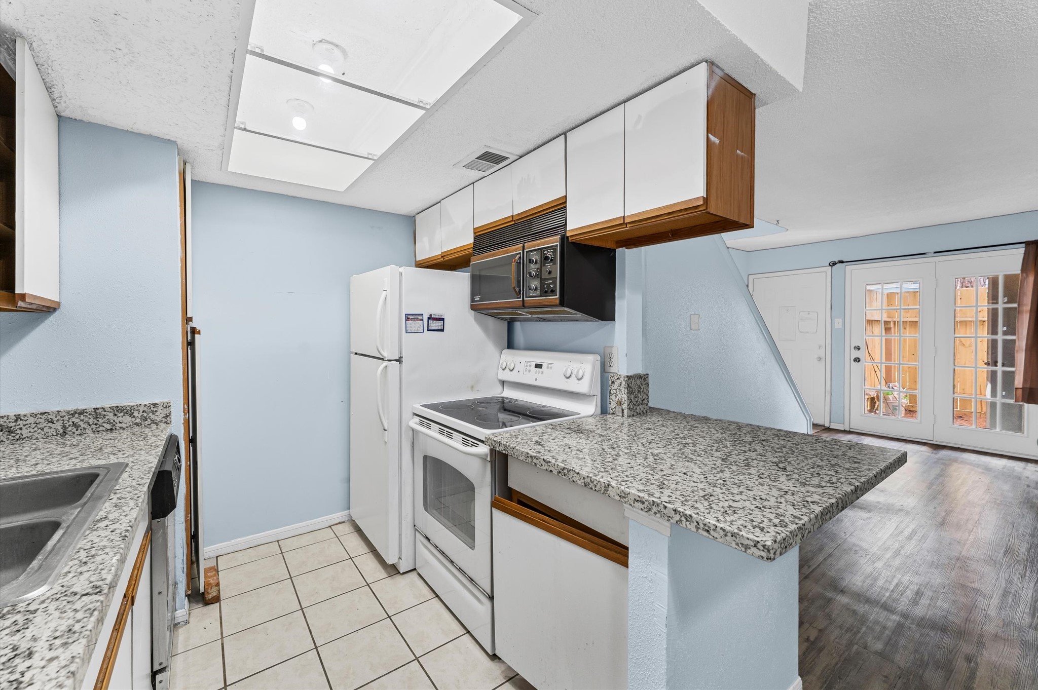 7402 Alabonson Road, Unit 303 Houston, TX 77088 - Photo 6 of 20 a kitchen with stainless steel appliances granite countertop a stove a refrigerator and a sink