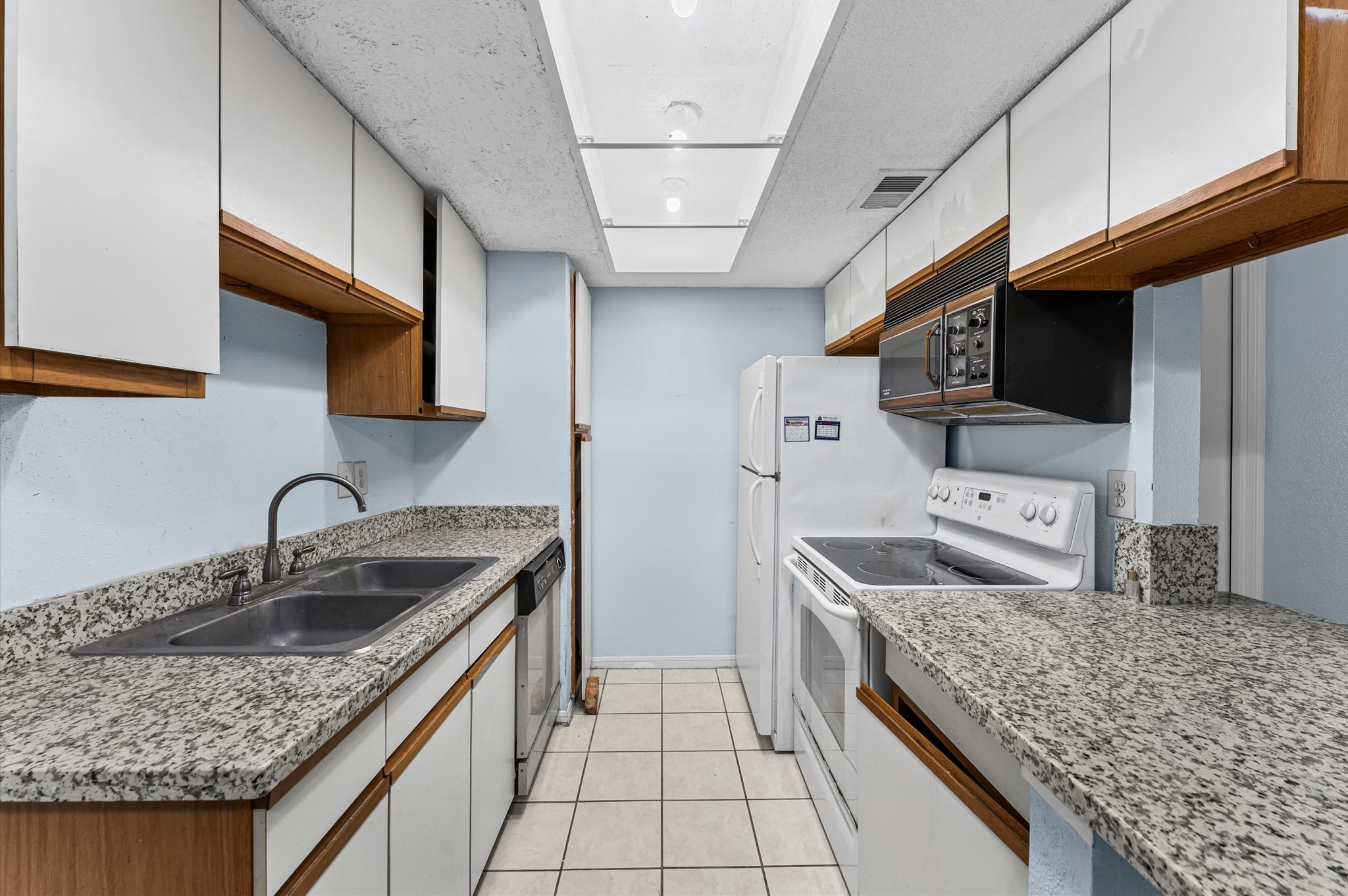 7402 Alabonson Road, Unit 303 Houston, TX 77088 - Photo 7 of 20 a kitchen with stainless steel appliances granite countertop a sink stove and refrigerator