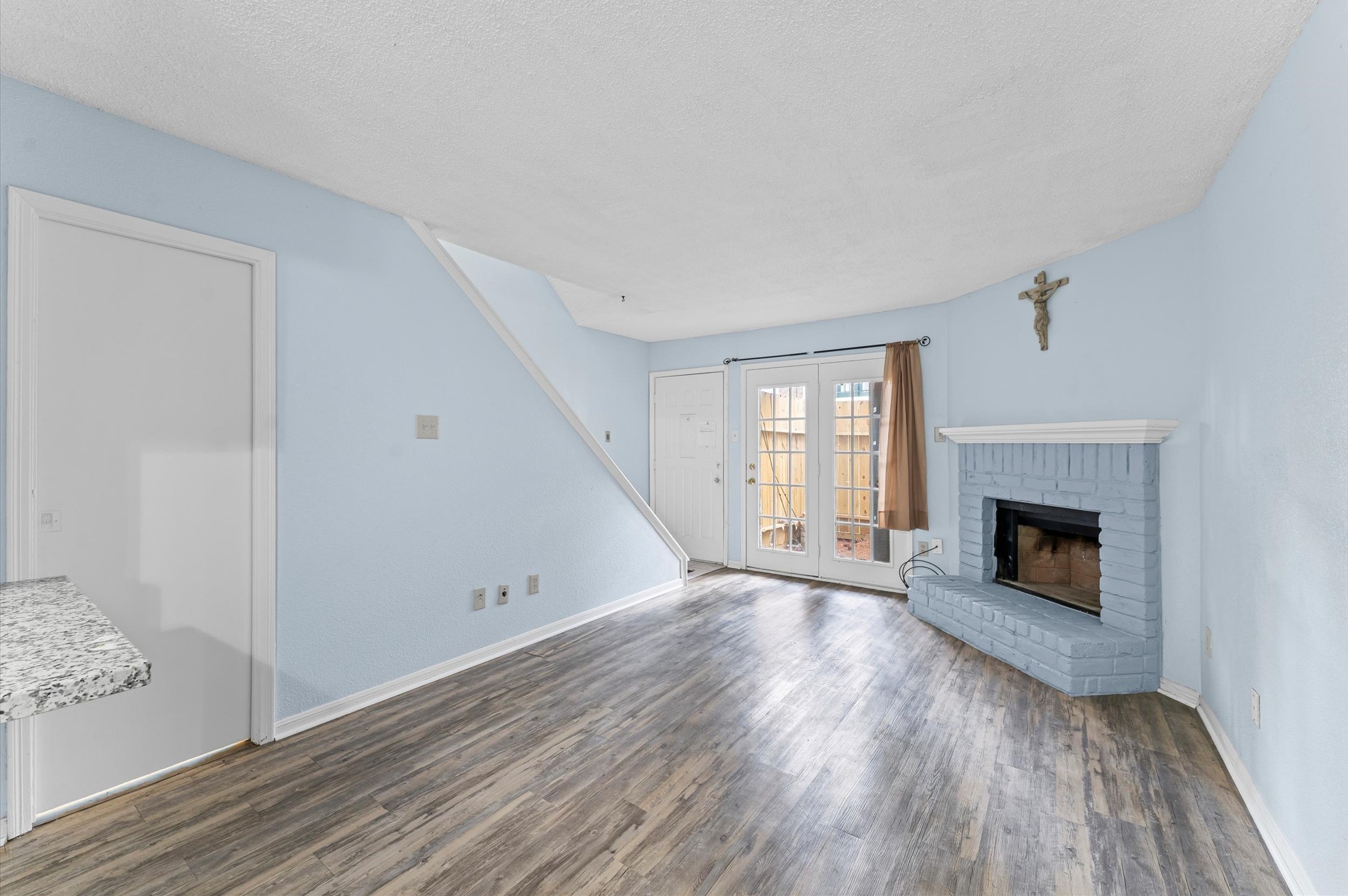 7402 Alabonson Road, Unit 303 Houston, TX 77088 - Photo 9 of 20 a view of an empty room with wooden floor fireplace and a window