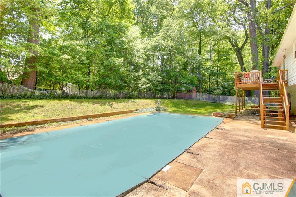 50 Wallace Road Middletown, NJ 07748 - Photo 7 of 24 a view of a swimming pool with lawn chairs and large trees