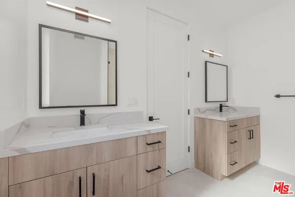 a bathroom with a double vanity sink mirror and