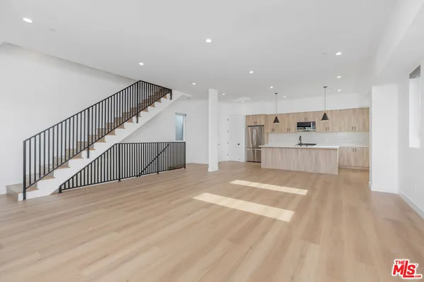a view of kitchen with wooden floor and electronic appliances