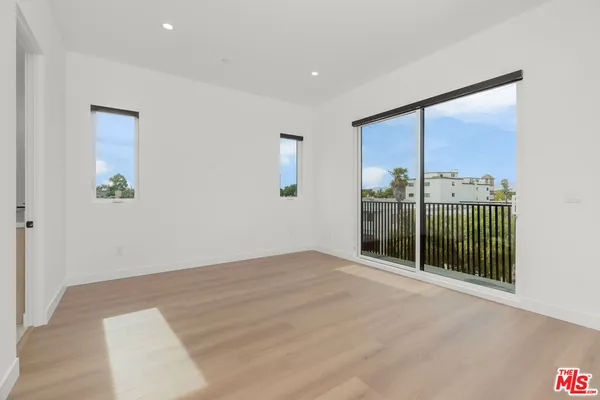 an empty room with sliding door and windows