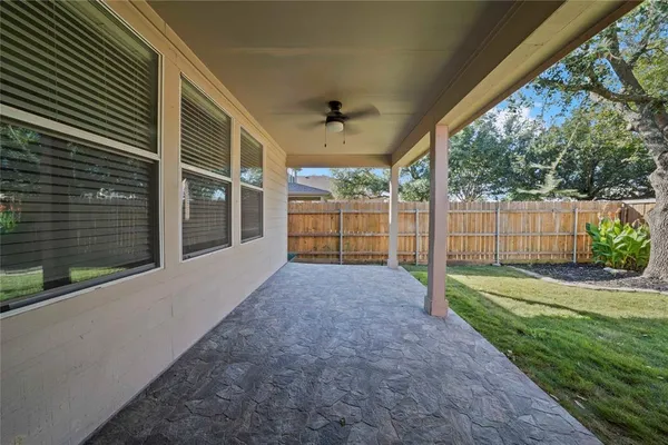 a view of a backyard with wooden fence and floor