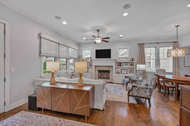 a living room with furniture kitchen view and a chandelier