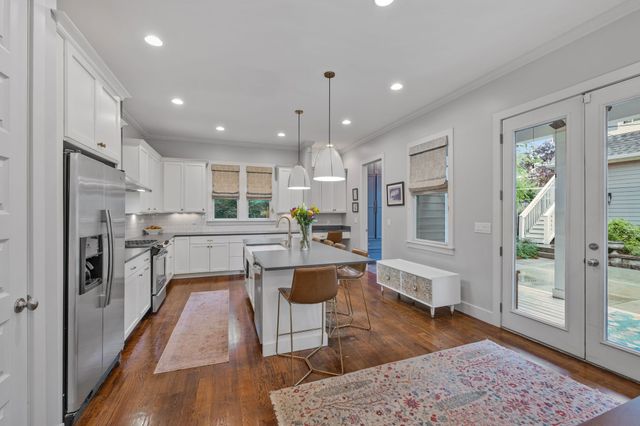 a kitchen with stainless steel appliances kitchen island granite countertop a stove a refrigerator and a wooden cabinets