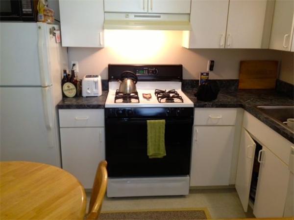 985 Tremont Street, Unit 985 Boston, MA 02120 - Photo 5 of 12 a kitchen with a stove and a refrigerator