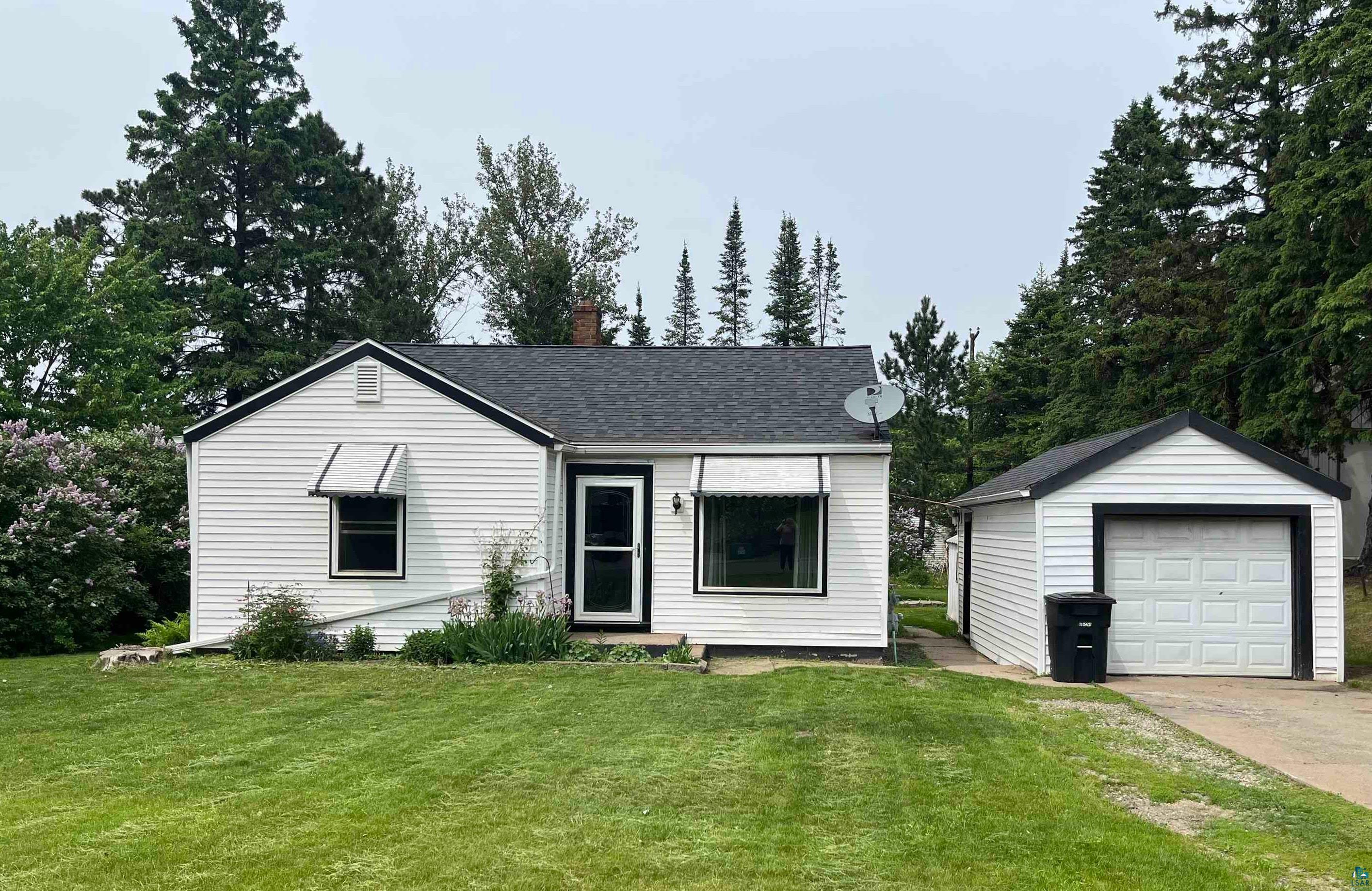 3 Merritt Drive Virginia, MN 55792 - Photo 48 of 48 White siding exterior featuring black trim accents, a dark shingle roof, and two window awnings