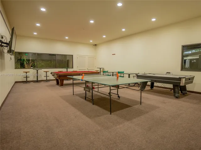 a living room with furniture and a pool table