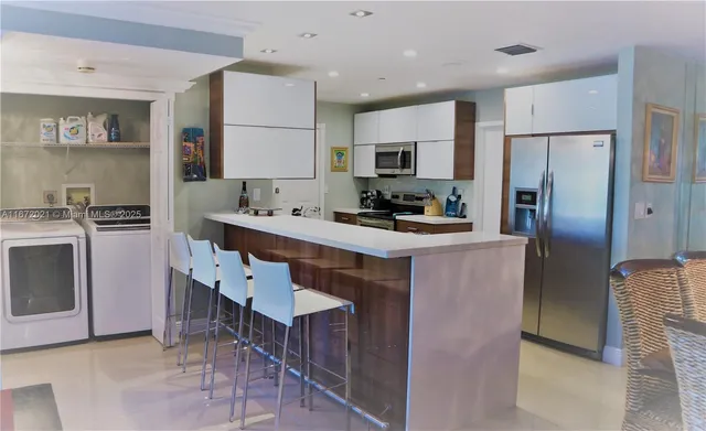 a kitchen with kitchen island a sink stove and refrigerator