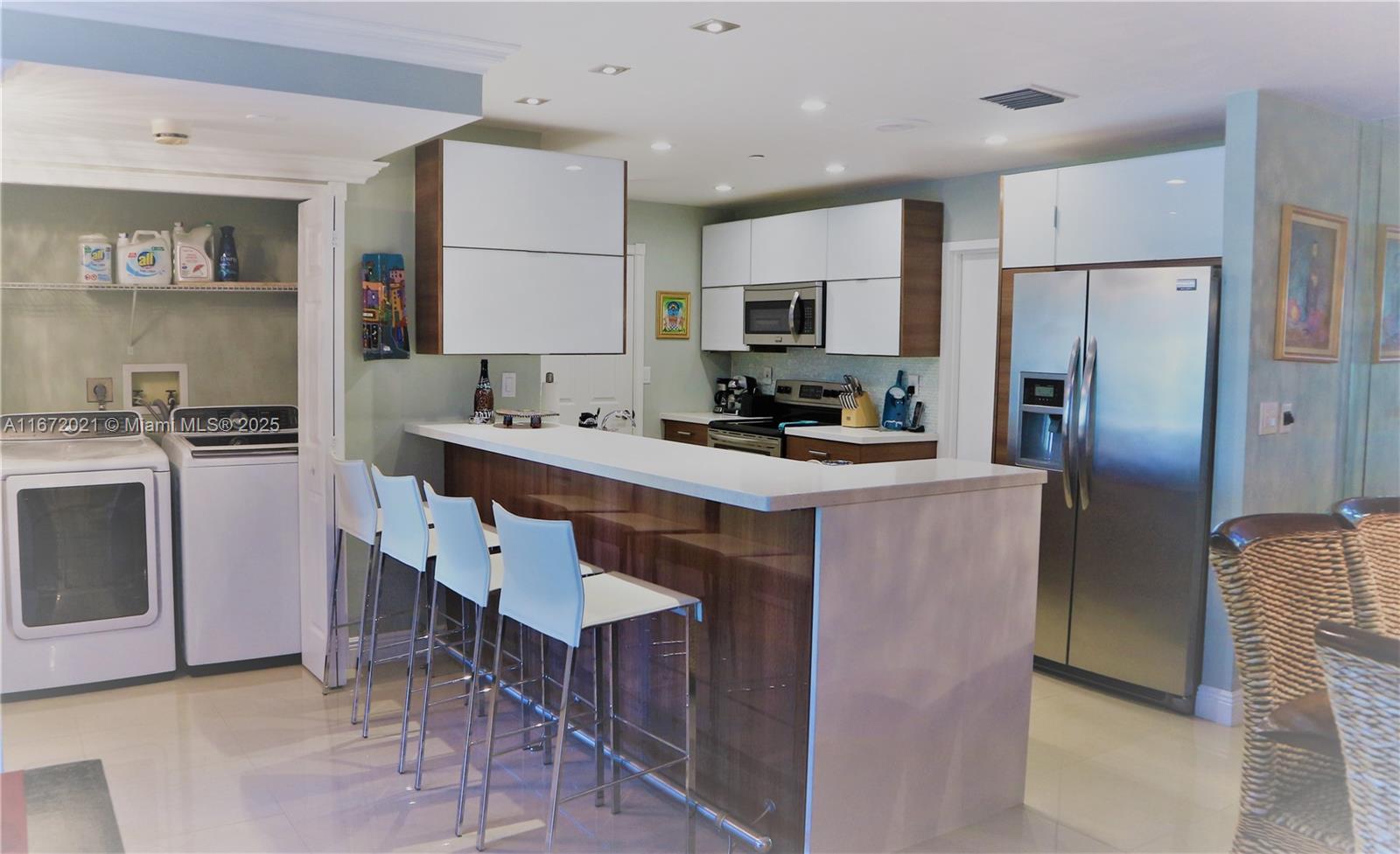 151 Crandon Boulevard, Unit 430 Key Biscayne, FL 33149 - Photo 4 of 26 a kitchen with kitchen island a sink stove and refrigerator