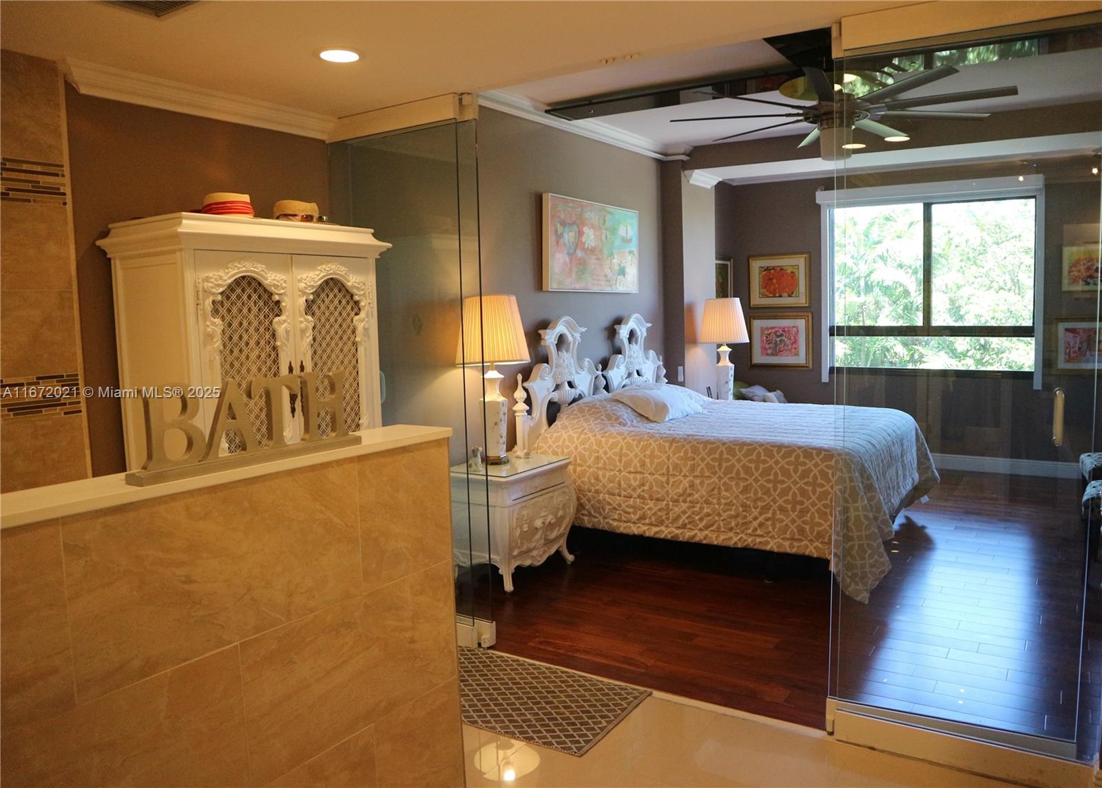 151 Crandon Boulevard, Unit 430 Key Biscayne, FL 33149 - Photo 6 of 26 a bedroom with a bed and a chandelier