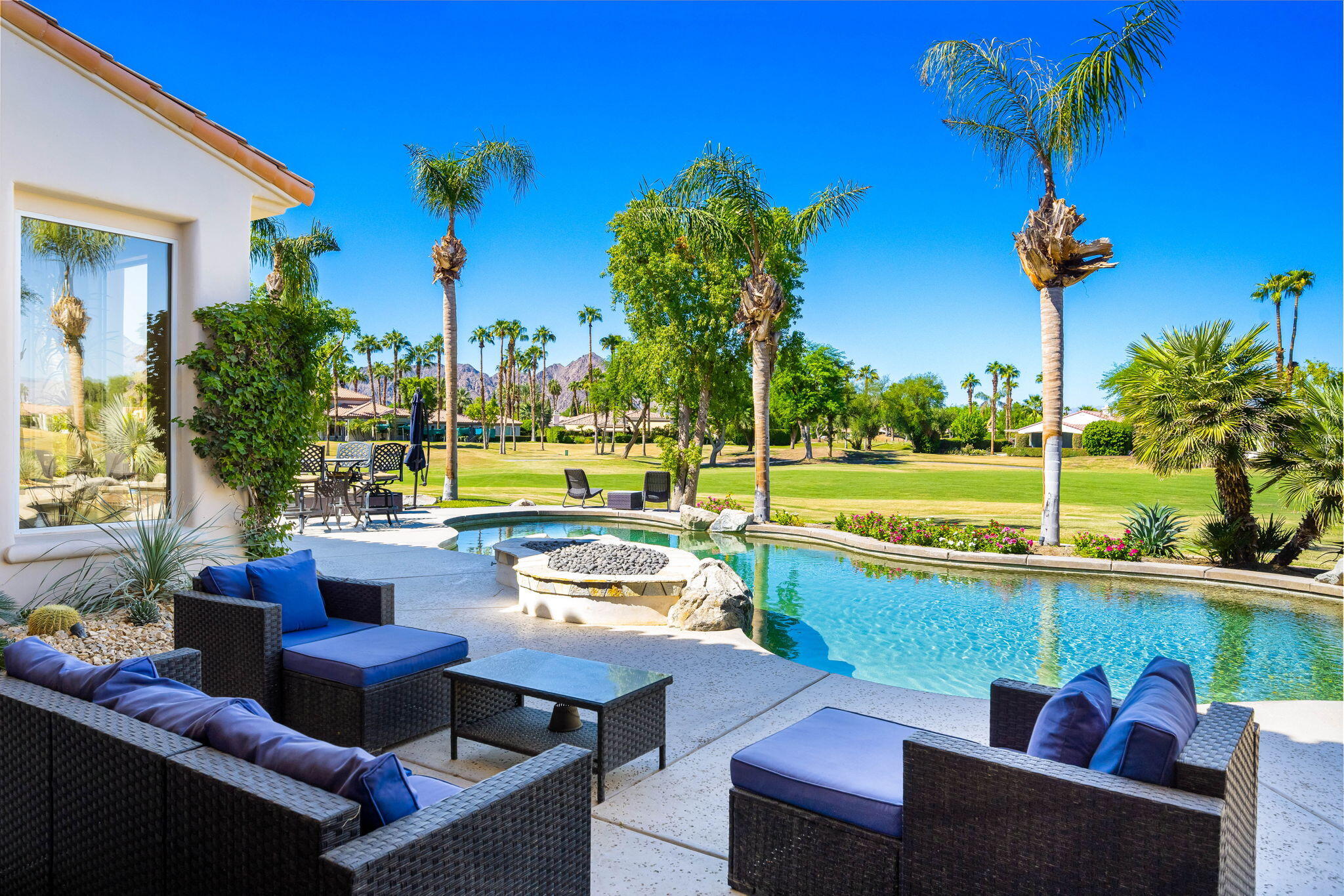 a view of a chairs and table in patio with a swimming pool