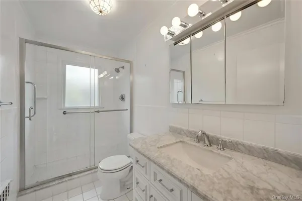a bathroom with a granite countertop sink a toilet and shower