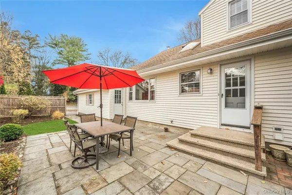 a patio with a table and chairs under an umbrella