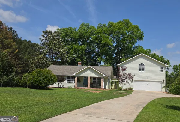 a front view of a house with a yard and trees