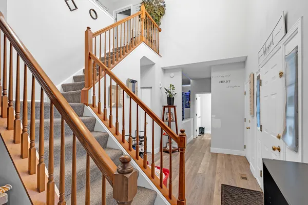 a view of staircase with lots of frames on wall and wooden floor