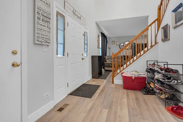 a hallway with stairs and wooden floor