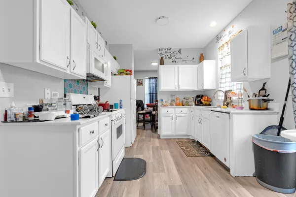 a kitchen with granite countertop a sink cabinets stainless steel appliances and white cabinets