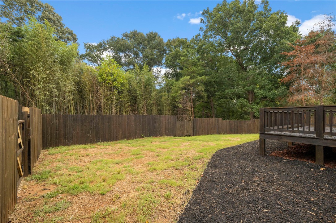 474 Bryant Road Pelzer, SC 29669 - Photo 40 of 44 Mature trees frame a spacious, fully fenced yard complete with an elevated wooden deck.