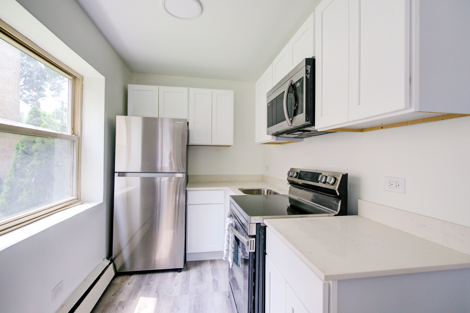 7250 North Western Avenue, Unit 306 Chicago, IL 60645 - Photo 13 of 17 a kitchen with stainless steel appliances a refrigerator microwave and sink
