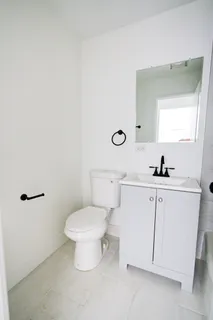 a bathroom with a toilet sink and mirror