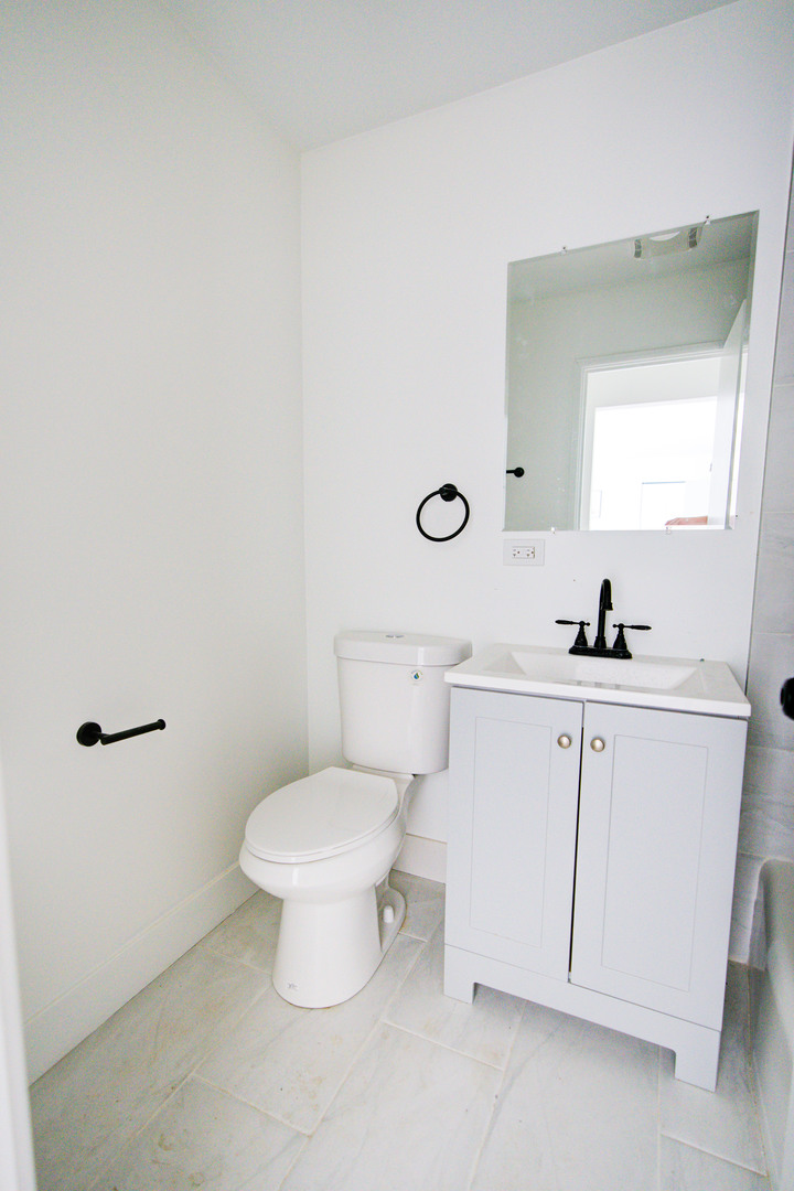 7250 North Western Avenue, Unit 306 Chicago, IL 60645 - Photo 16 of 17 a bathroom with a toilet sink and mirror