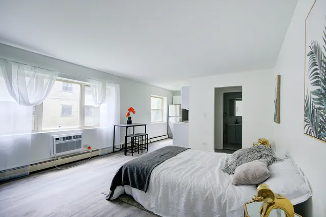 a bedroom with a bed and a large window