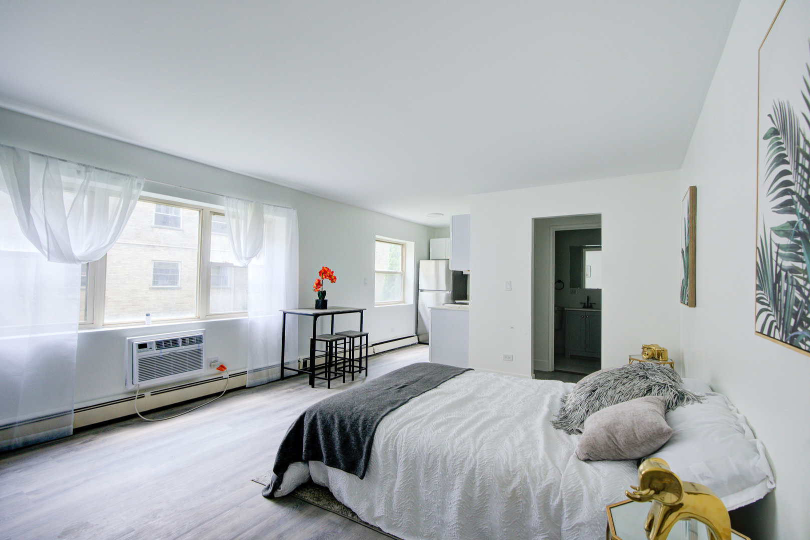 7250 North Western Avenue, Unit 306 Chicago, IL 60645 - Photo 10 of 17 a bedroom with a bed and a large window