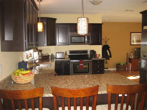 11 Comstock Place Rochester, MA 02770 - Photo 7 of 21 a kitchen with kitchen island granite countertop a sink a stove and a wooden cabinets