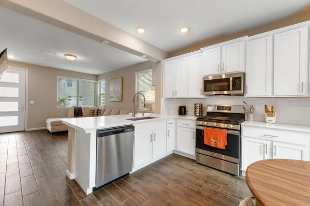 a kitchen with granite countertop a stove top oven sink and cabinets