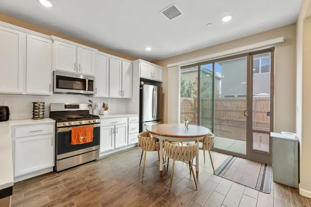 a kitchen with a stove a sink a microwave a refrigerator and a dining table