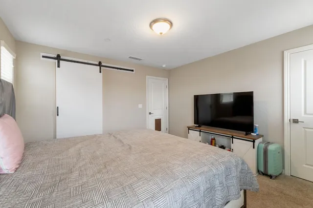 a bedroom with a flat screen tv a chandelier and a bed